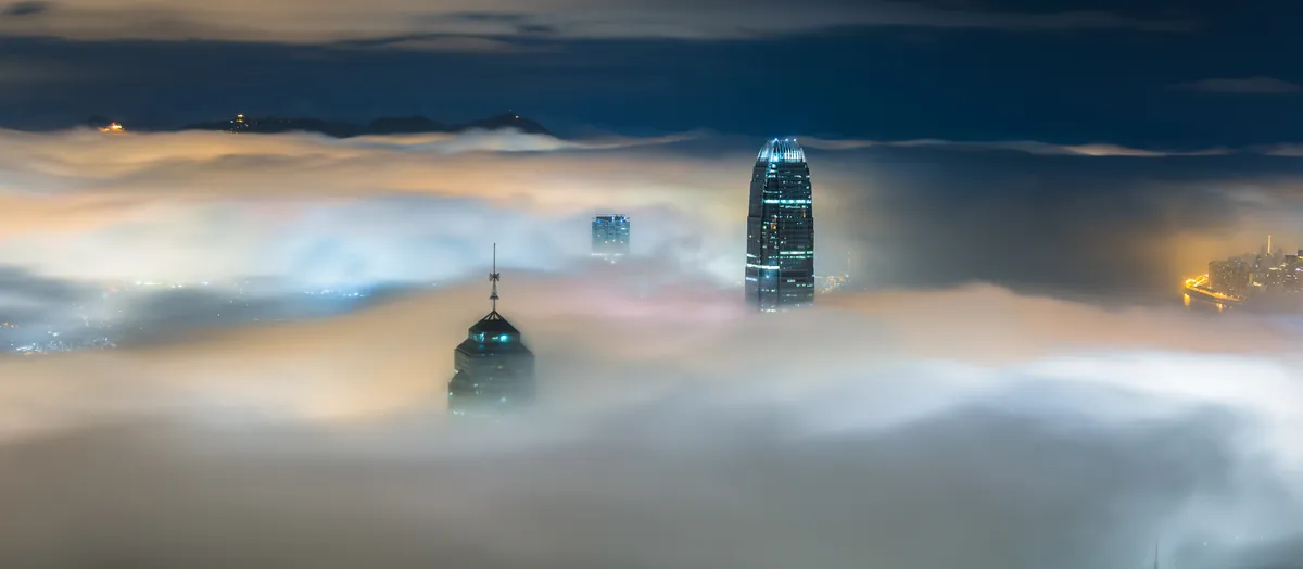 City skyscrapers covered in mist at night