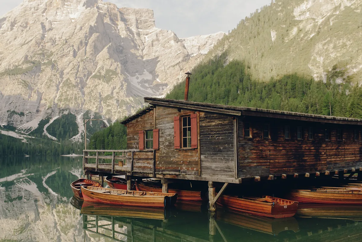 Italian Dolomites wooden house by lake mountain
