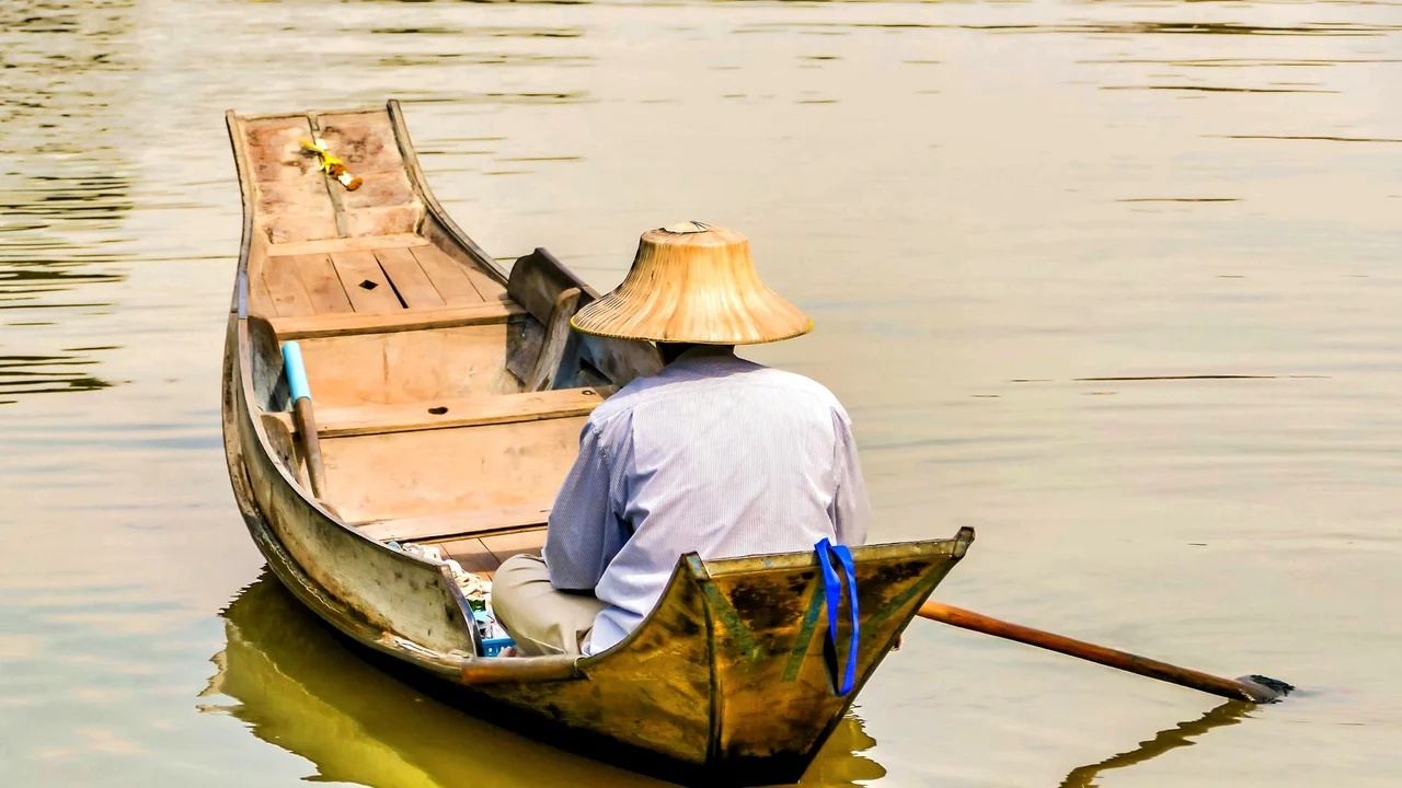 คนพายเรือในตลาดน้ำเวียดนามยามเช้า มองจากด้านหลัง