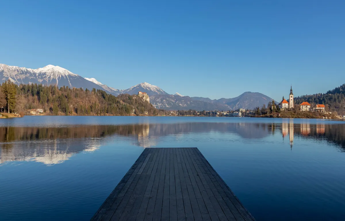 Lake reflection with mountains and old buildings